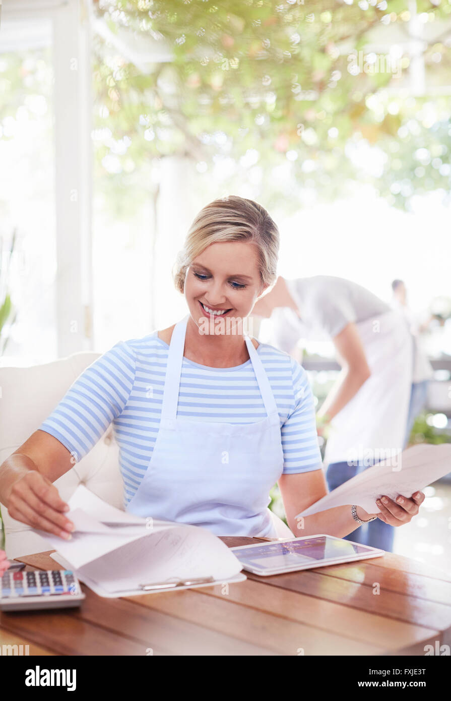 Sorridente titolare di azienda facendo di documenti cartacei Foto Stock