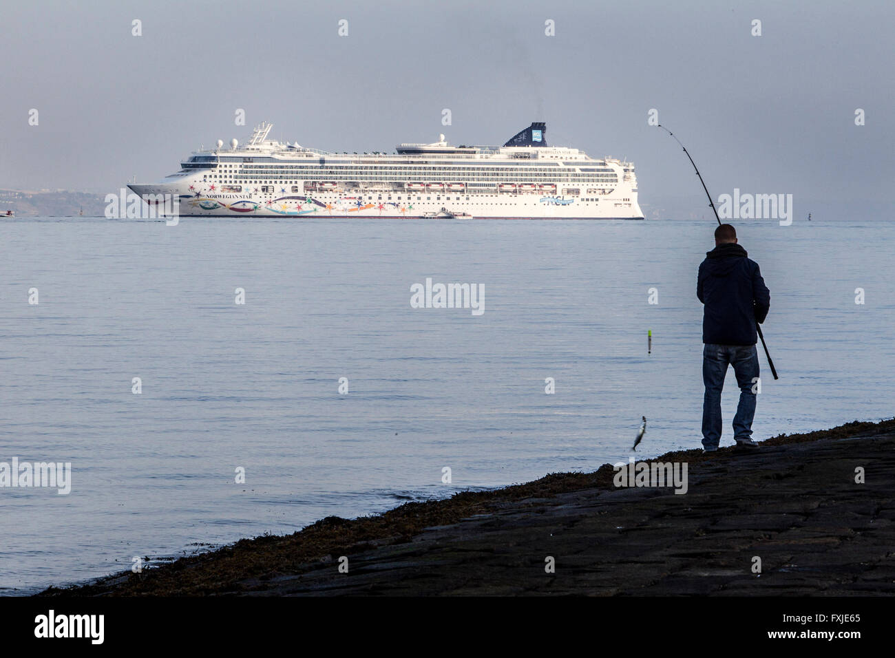 Luxury Liner sette mari avvicinando Edimburgo con uomo di pesca in primo piano Foto Stock