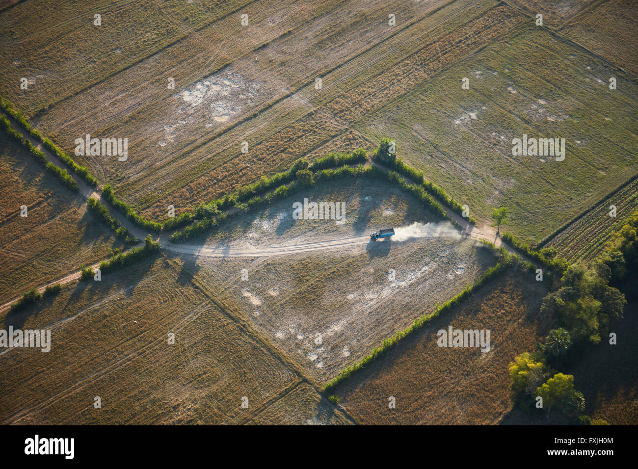 Carrello sulla pista polverosa e terreni agricoli, vicino a Siem Reap, Cambogia - aerial Foto Stock