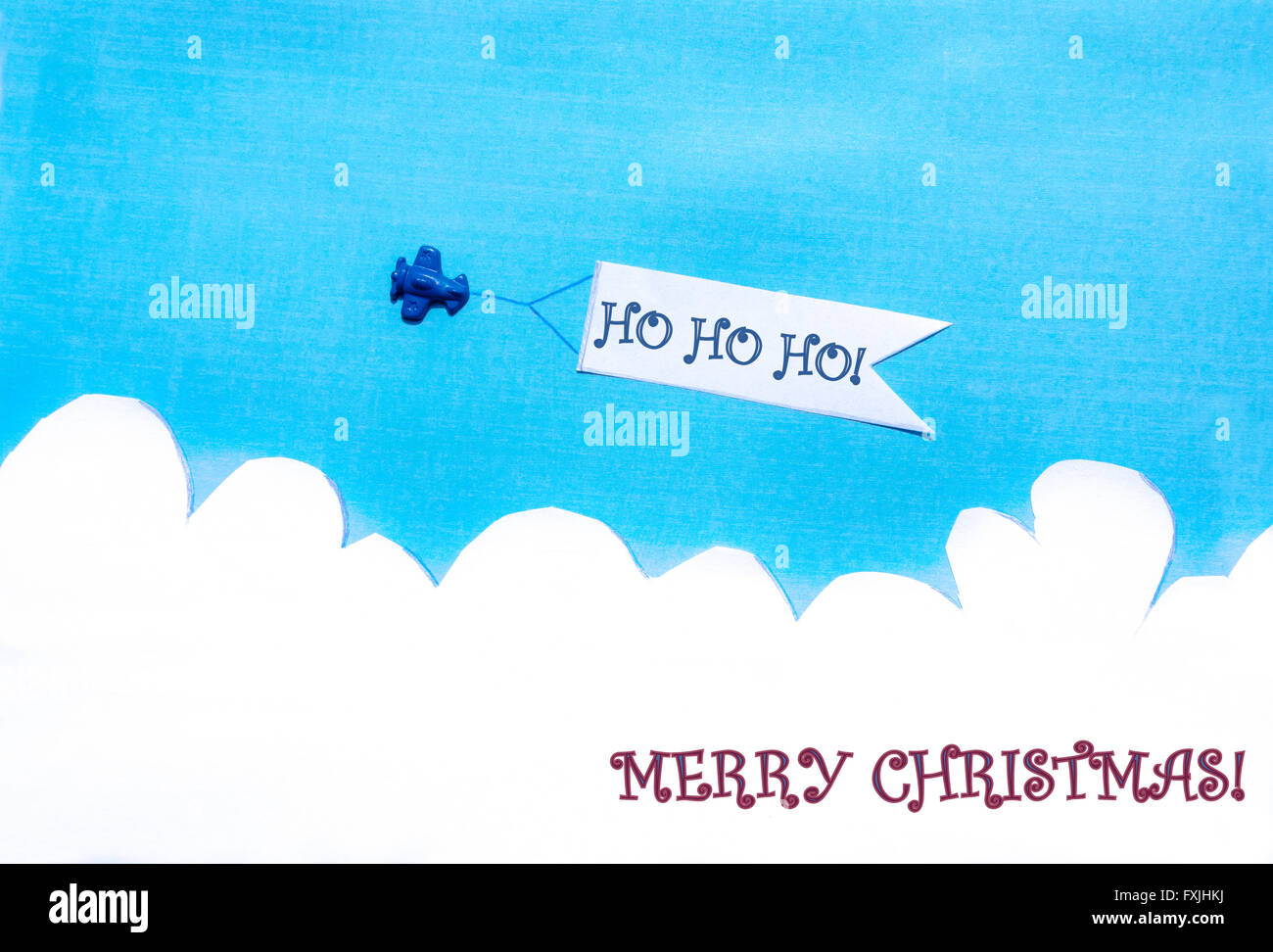 Piano tirando un banner bianco sul cielo blu. Auguri di Buon Natale. Ho ho ho! Foto Stock