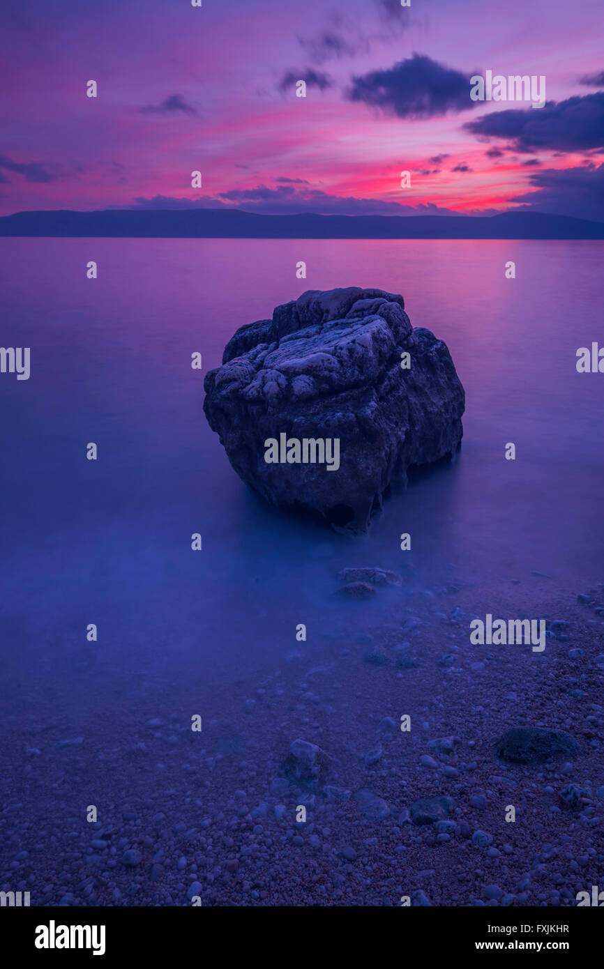 Colori vividi lonely rock Tramonto Tramonto sera mare spiaggia lunga esposizione Foto Stock