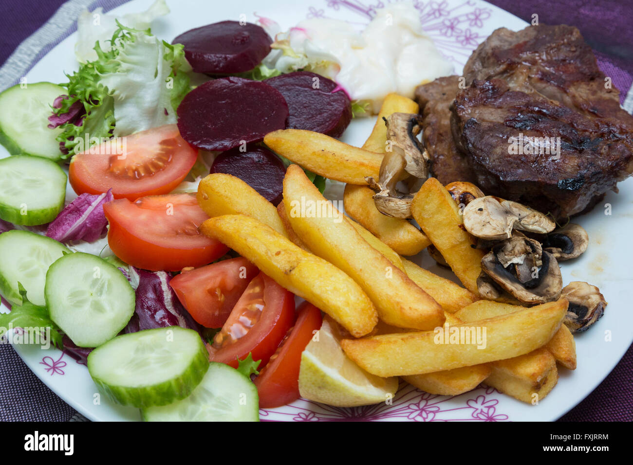 Bistecca di manzo, patate fritte e insalata mista Foto Stock