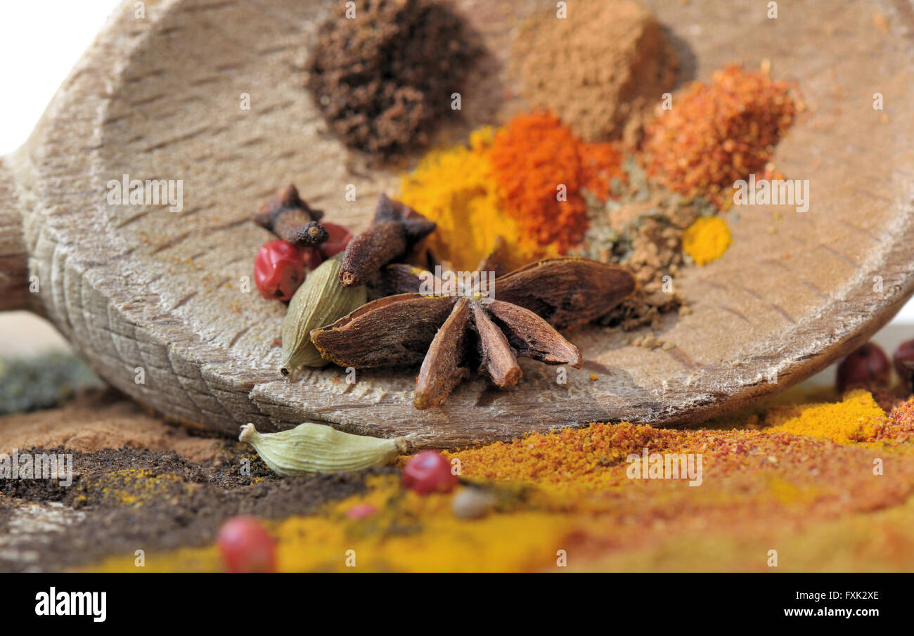 Anice e spezie colorate su un cucchiaio di legno Foto Stock
