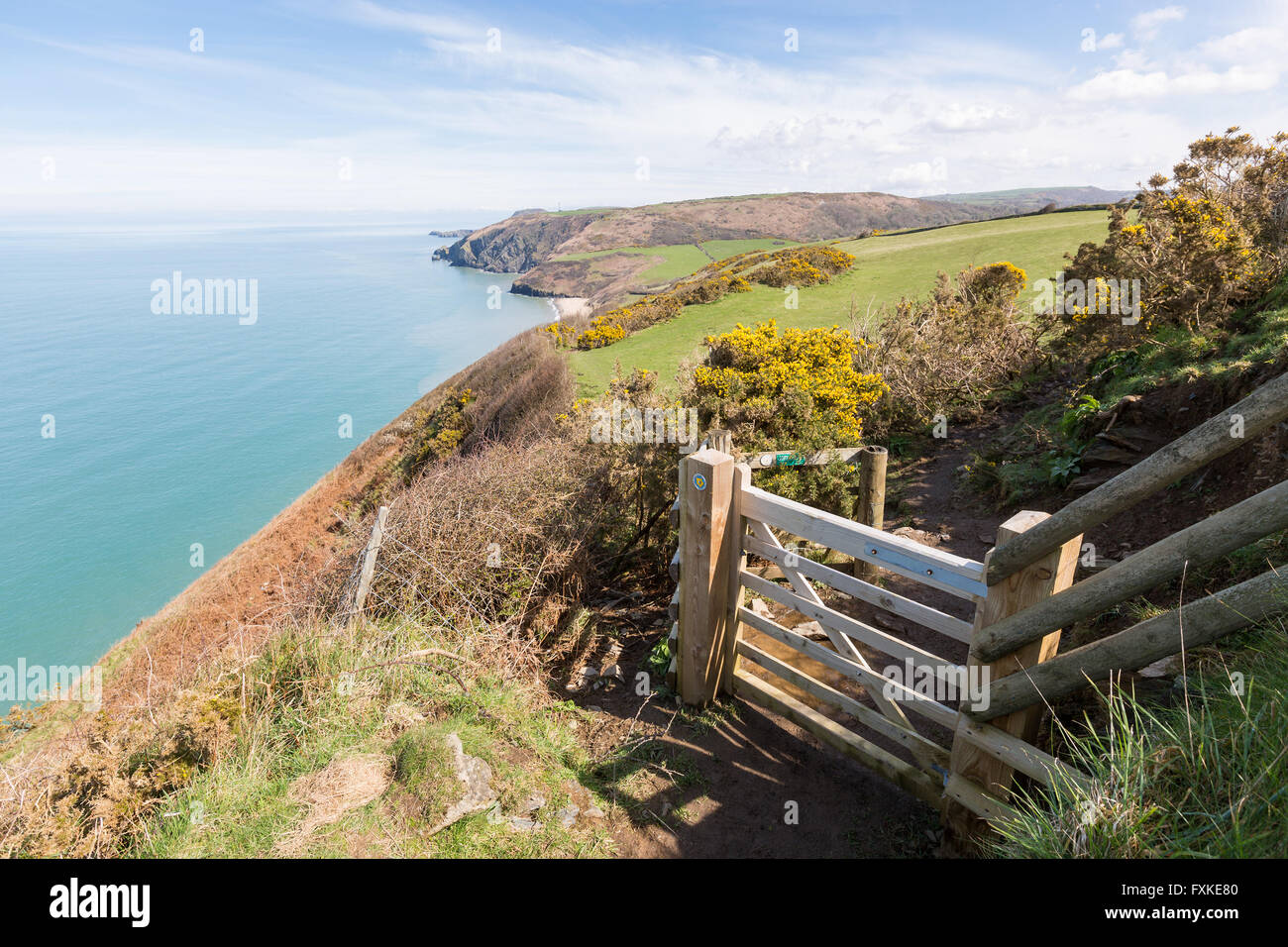 Cancello in legno che conduce al Cardigan Bay sentiero costiero. Penbryn spiaggia può essere visto in lontananza. Foto Stock
