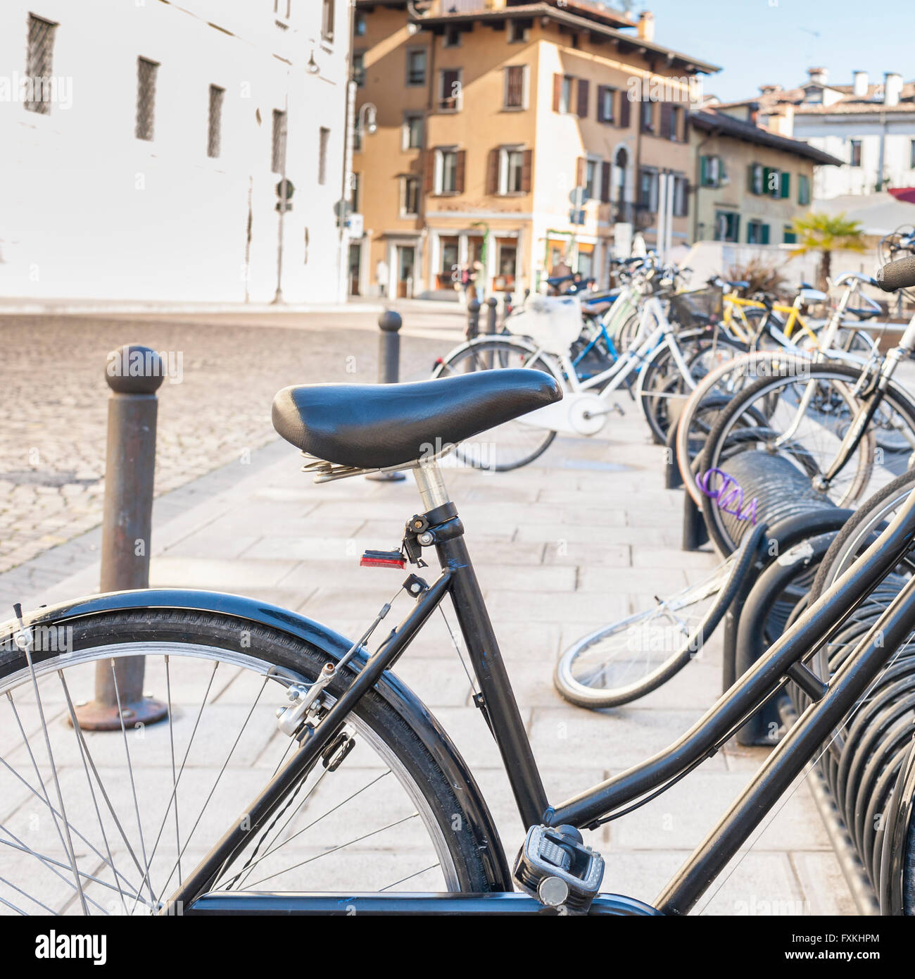 Bicicletta parcheggiata su un rack in una grande città. Foto Stock