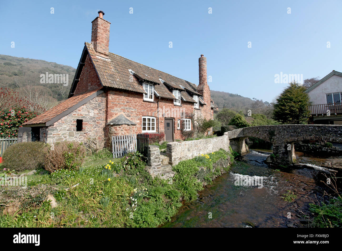 Allerford è un grazioso villaggio inglese con una ford,packhorse bridge e molti cottage in pietra con round, forno del pane camini. Foto Stock