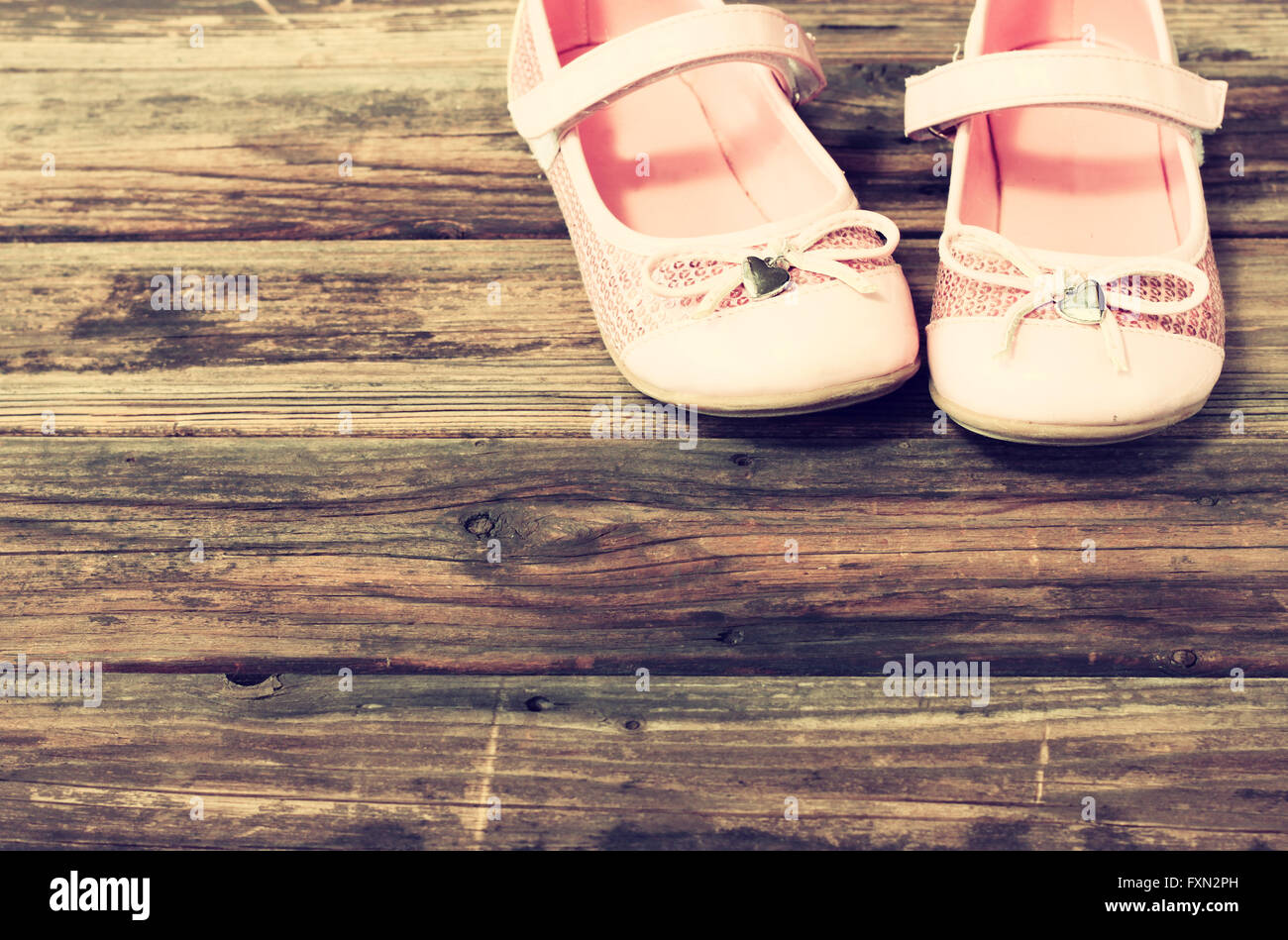 Scarpe bambina oltre il ponte di legno piano. immagine filtrata. Foto Stock