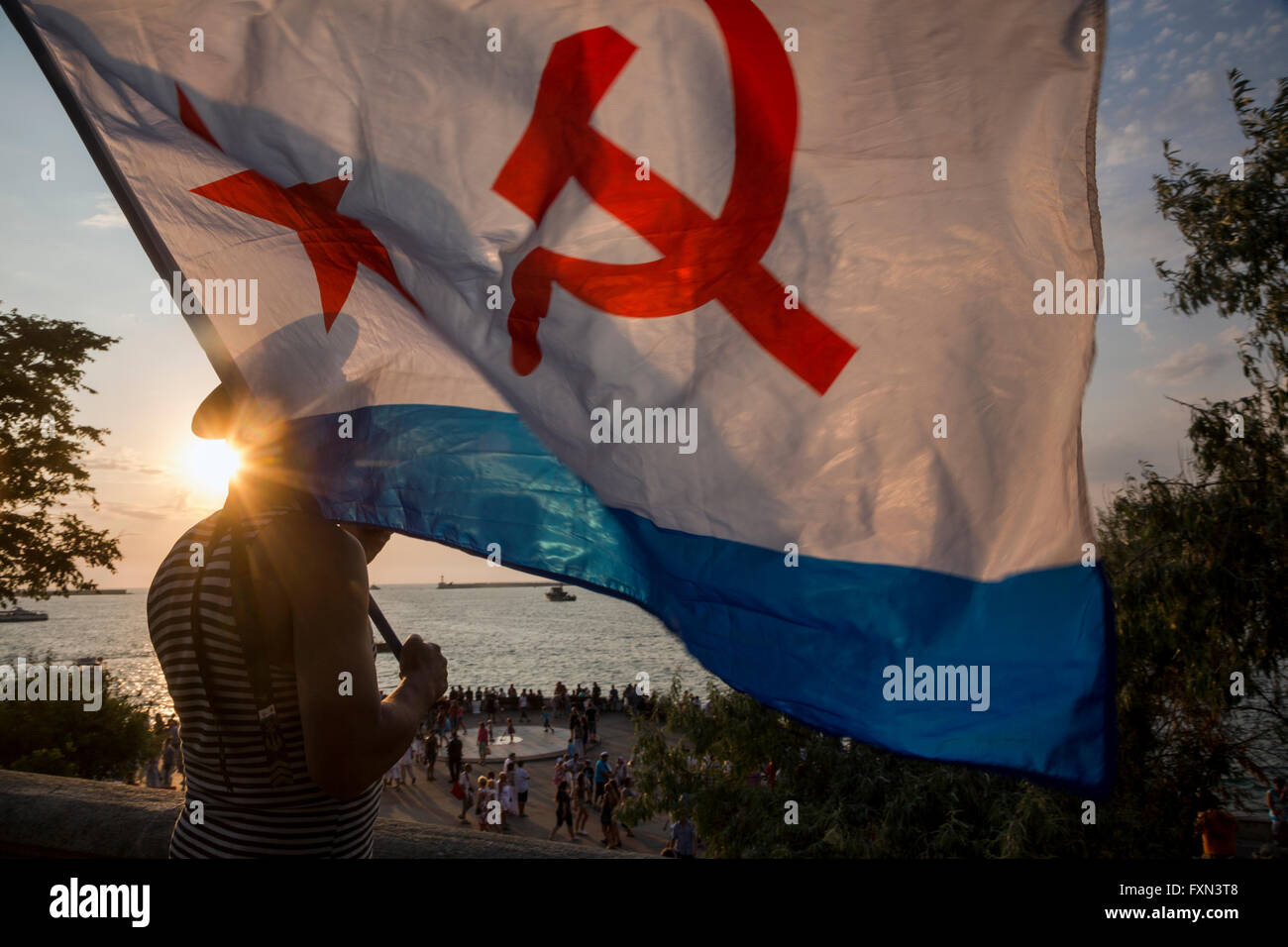 Ex marinaio Marina porta il navale sovietica bandiera durante la celebrazione della Marina russa giorno in città Sebastopoli, Crimea Rep Foto Stock