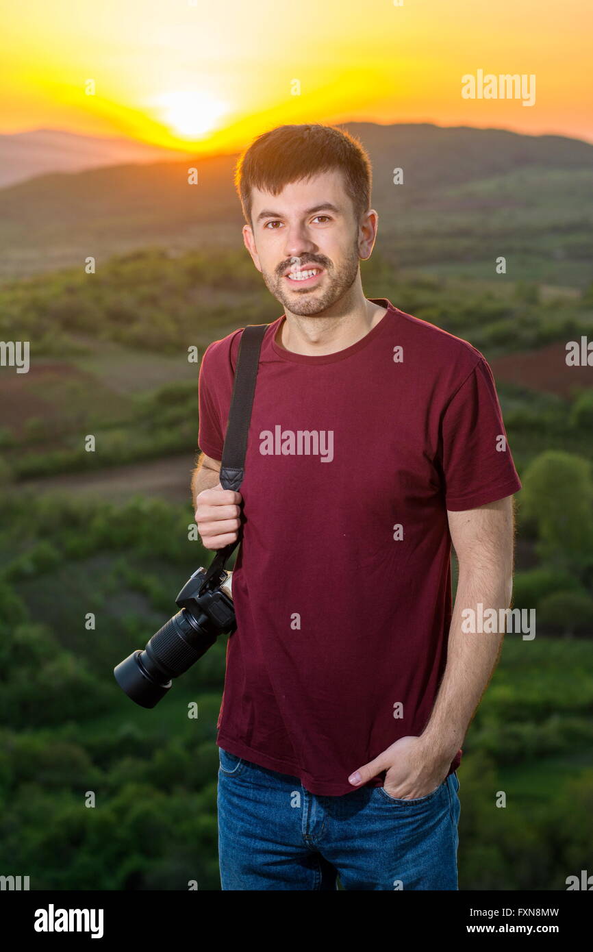 Giovane fotografo godersi il tramonto su un viaggio escursionistico Foto Stock