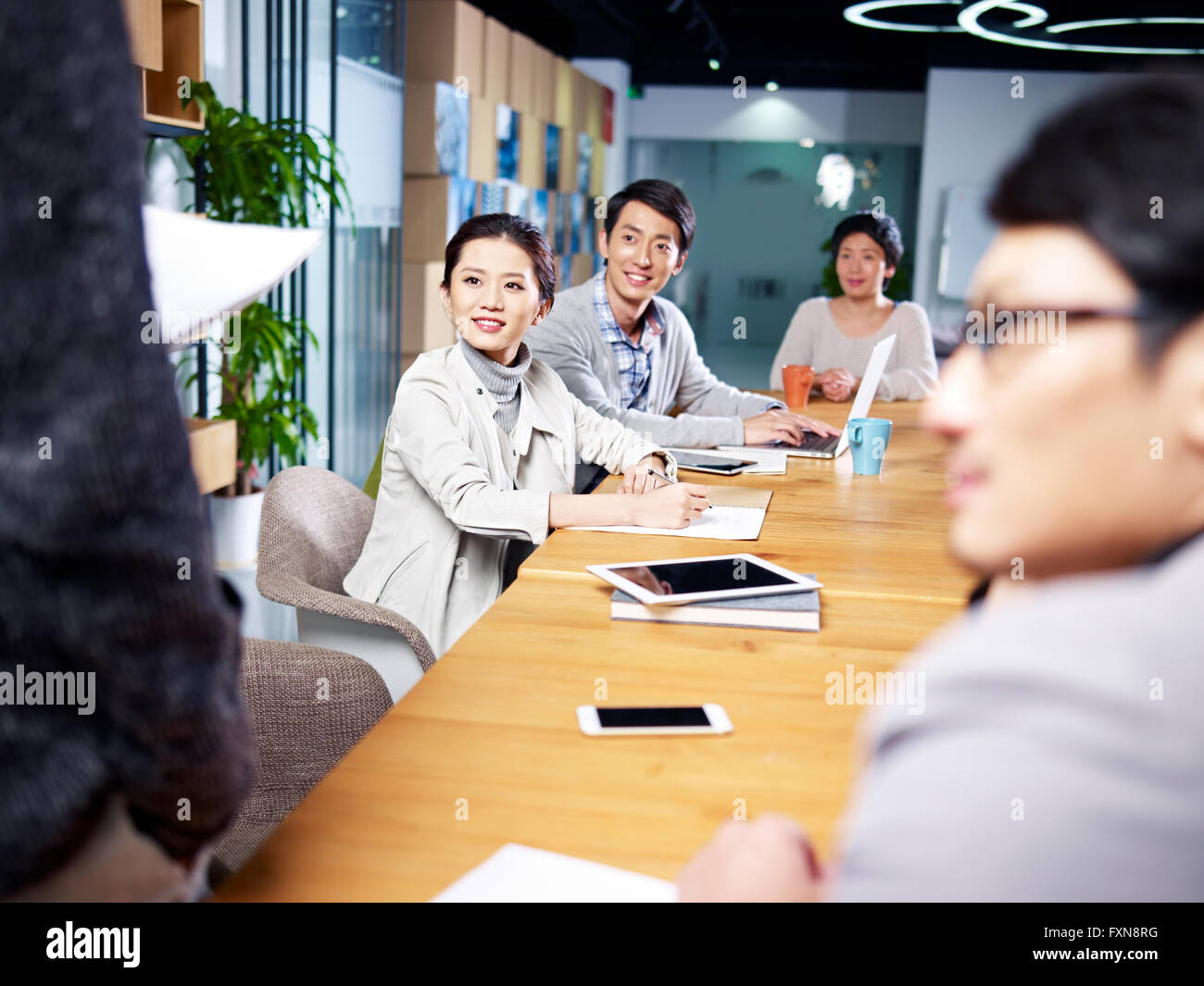 Un team di giovani asian business persone in riunione Foto Stock