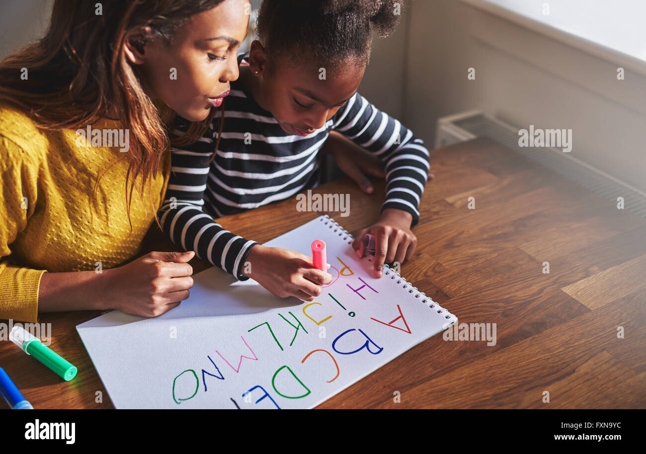 Imparare l'alfabeto a casa con la sua mamma, nero di madre e bambino Foto Stock