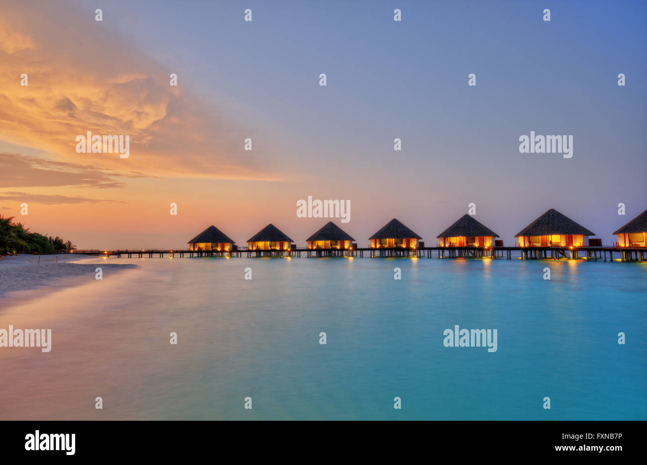 Ville sull'acqua alle Maldive resort Isola in sunset Foto Stock