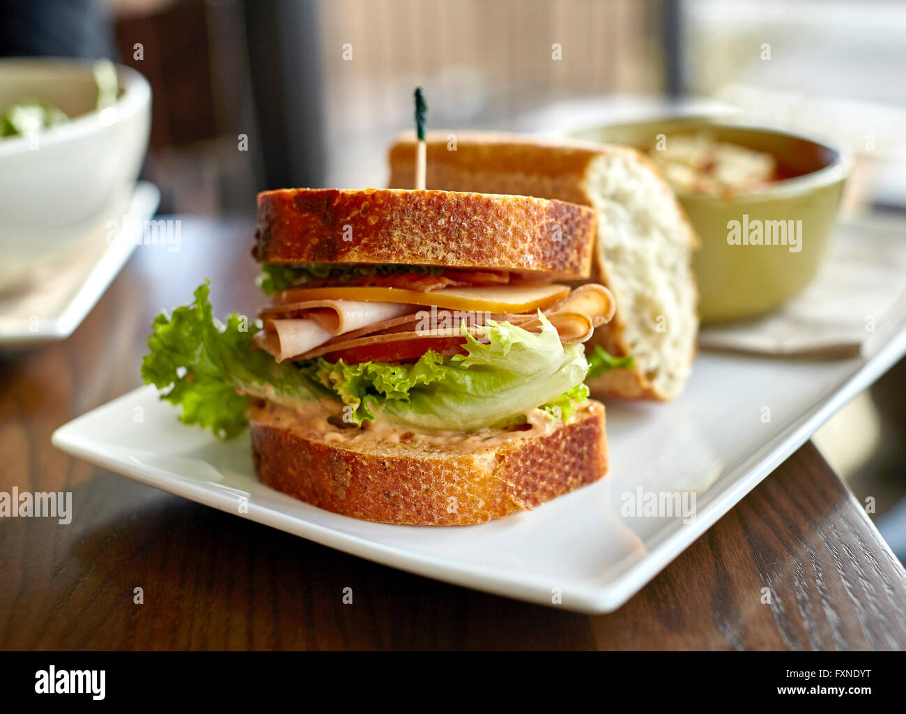 Sandwich di tacchino con pancetta e formaggio, lattuga e pomodoro mayonaise su pane di grano con zuppa Foto Stock