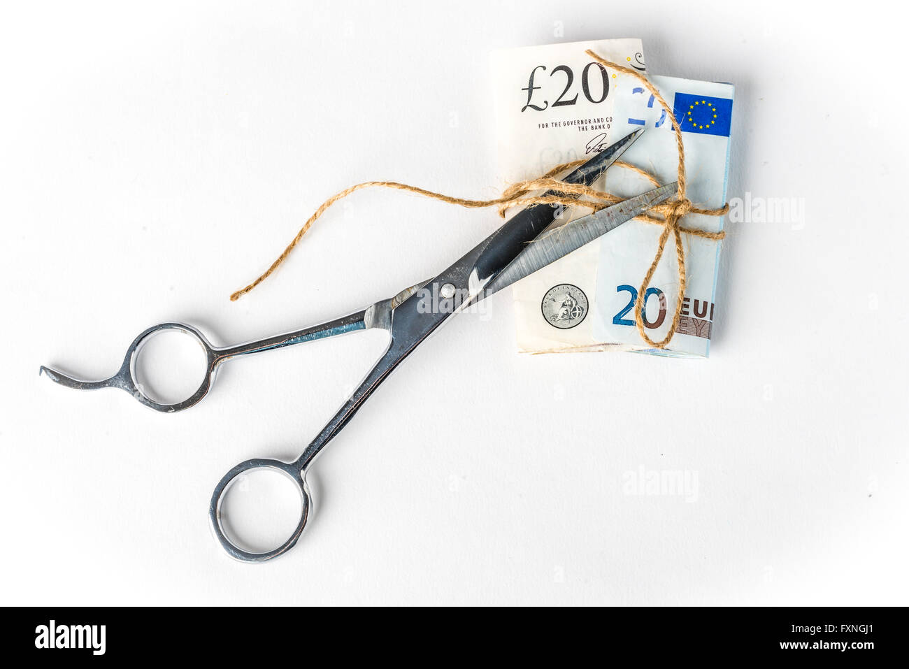 Libbre e le banconote in euro legato con una corda, con forbici e taglio Foto Stock