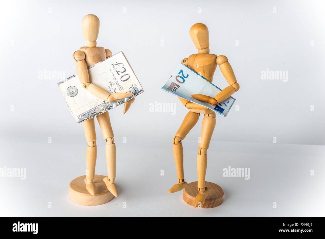 Manichini in legno con le libbre e le banconote in euro in mani Foto Stock