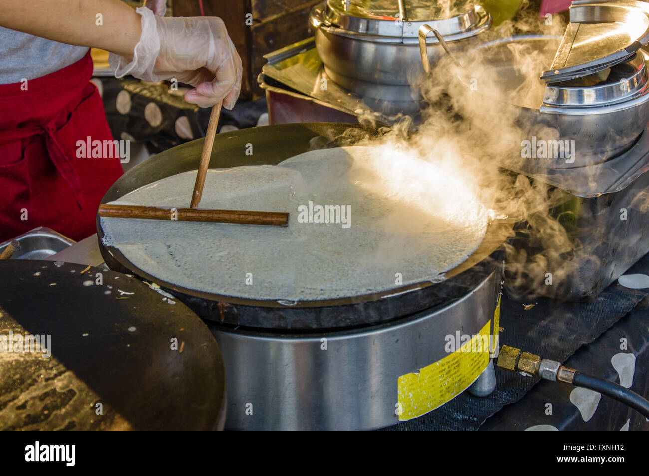 Cuocere rendendo crepes su un gas per fornello a un mercato di stand. Beaverton, Oregon Foto Stock