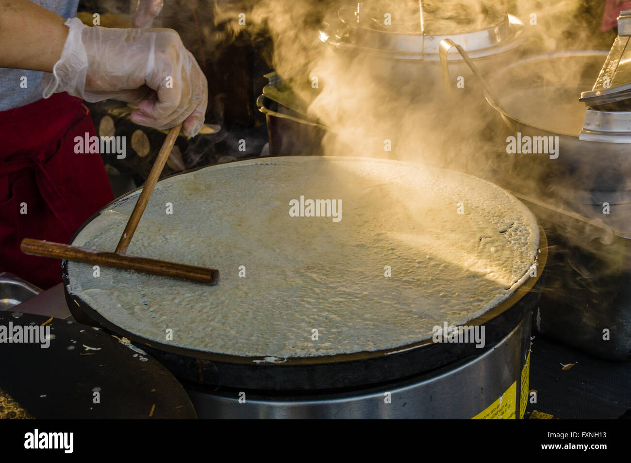 Cuocere rendendo crepes su un gas per fornello a un mercato di stand. Beaverton, Oregon Foto Stock