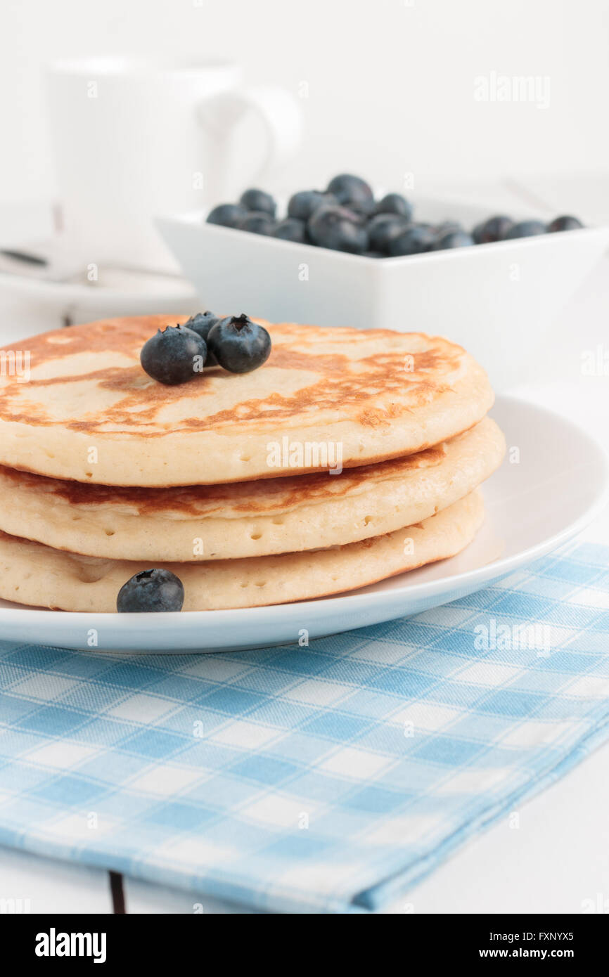 Latticello pancake con mirtilli in una luminosa sala colazione Foto Stock