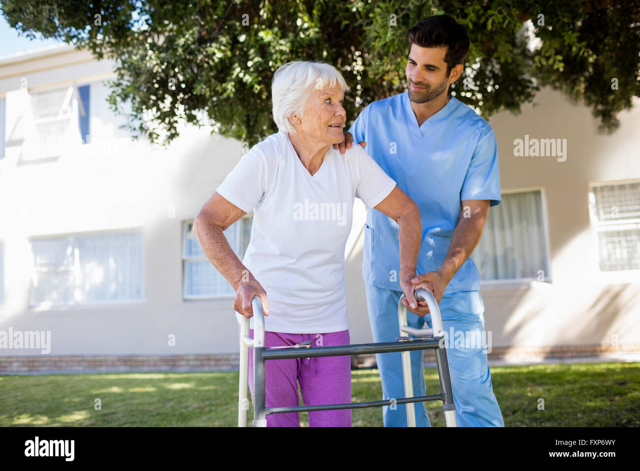 L'infermiera aiutando senior donna a camminare Foto Stock
