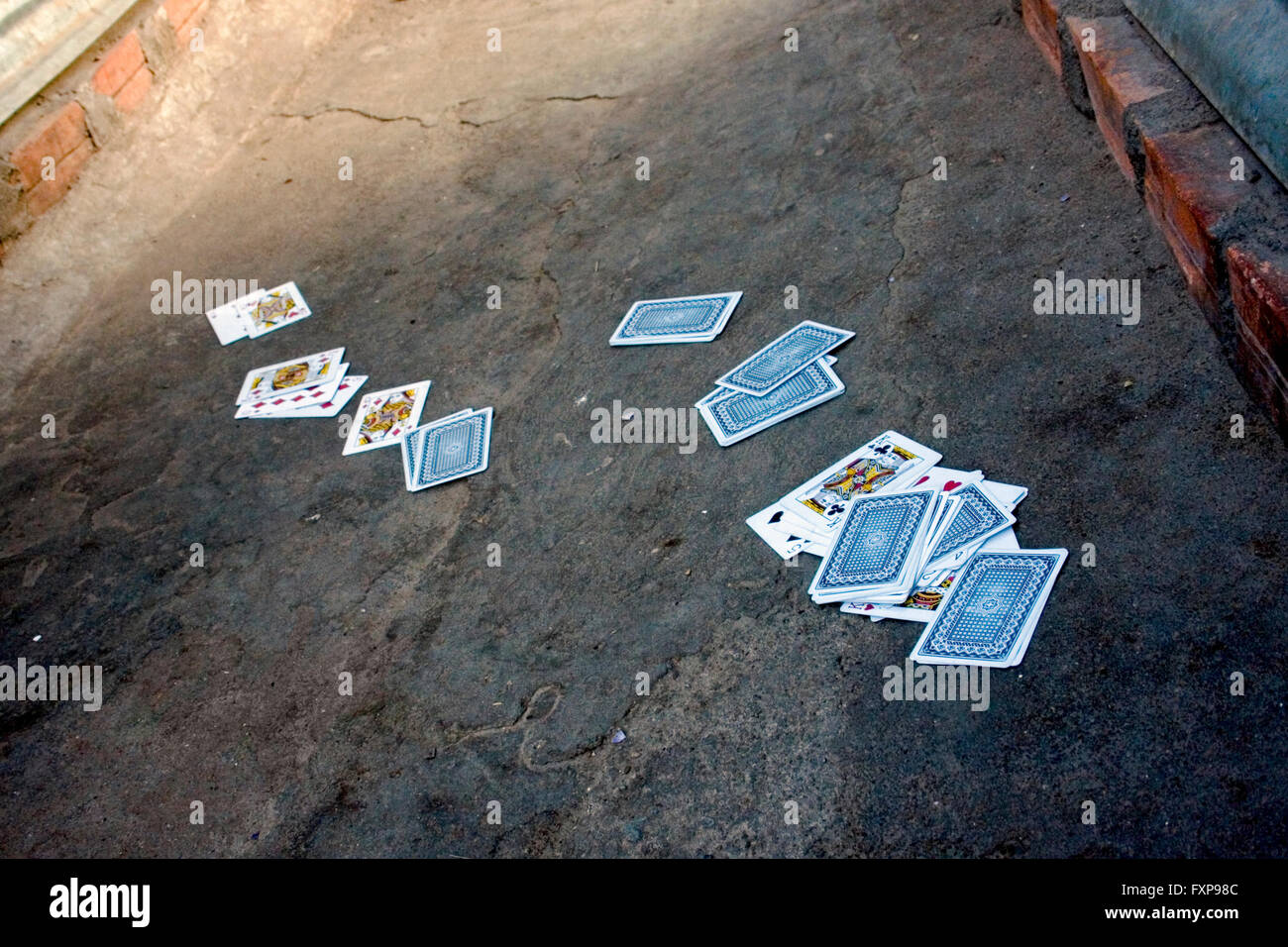 Un nuovo mazzo di carte da gioco utilizzati per un gioco di poker è sparsa su un marciapiede in una delle baraccopoli in Kampong Cham, Cambogia. Foto Stock