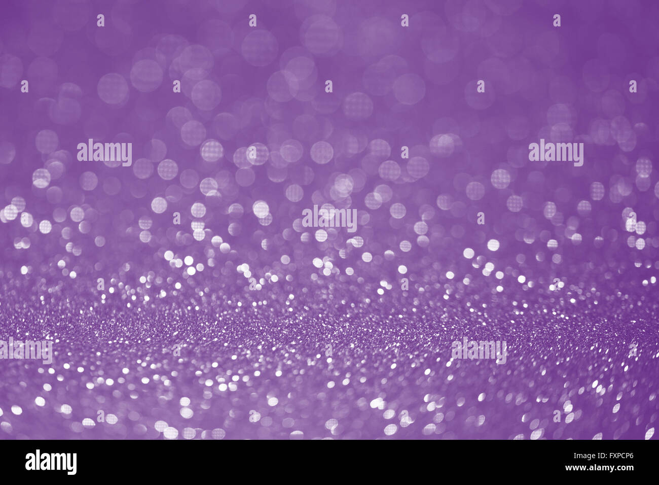 Viola glitter superficie con luce viola bokeh di fondo - che può essere utilizzato per lo sfondo per le occasioni speciali campagna promozionale o produ Foto Stock