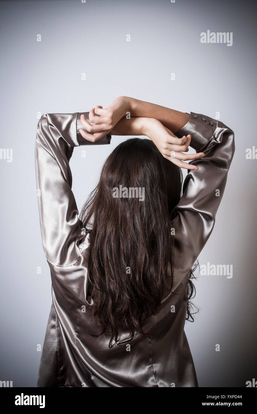 Vista posteriore di una giovane donna le mani sulla testa Foto Stock