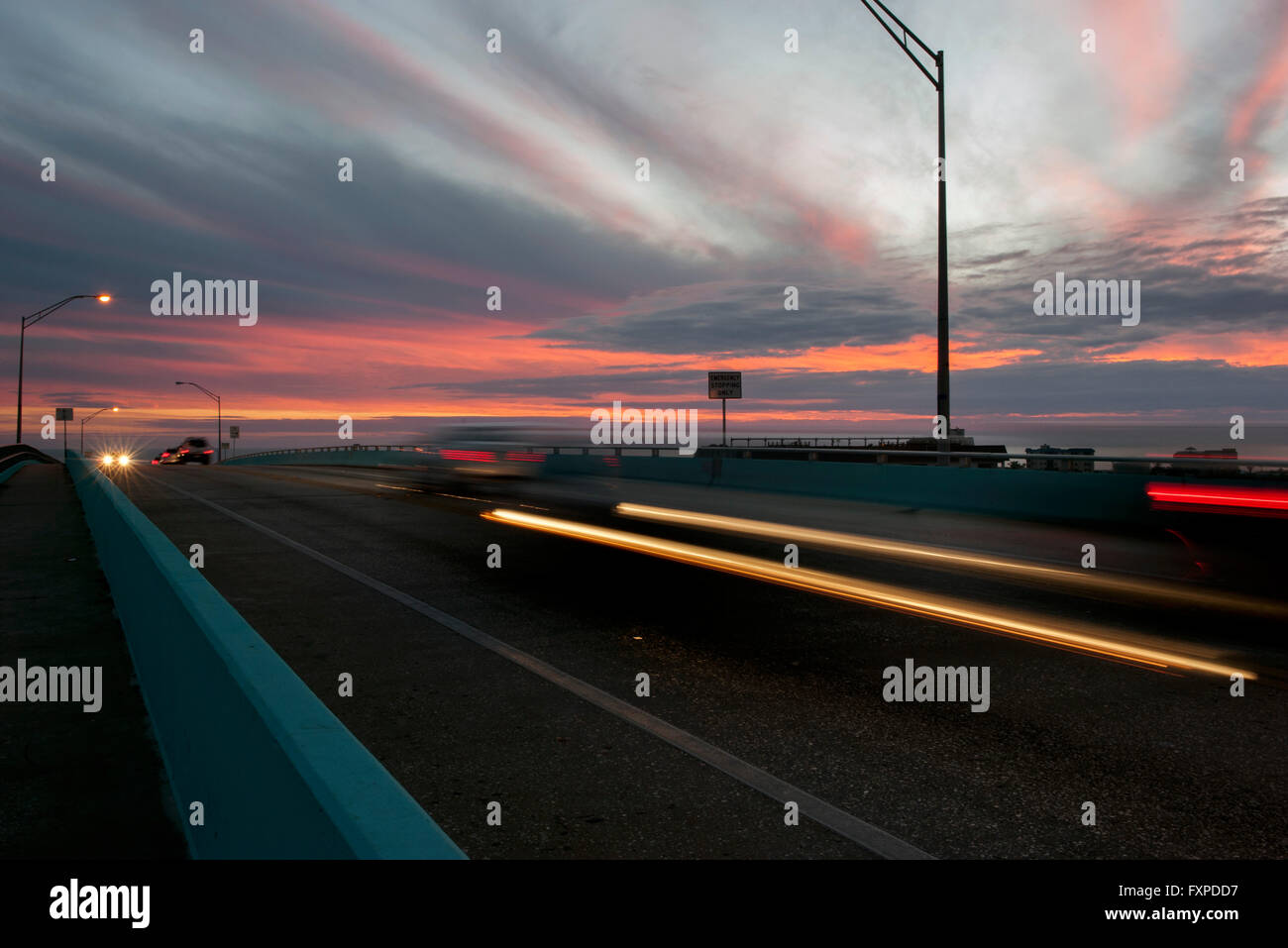 Sentieri di luce dal traffico su autostrada al tramonto Foto Stock