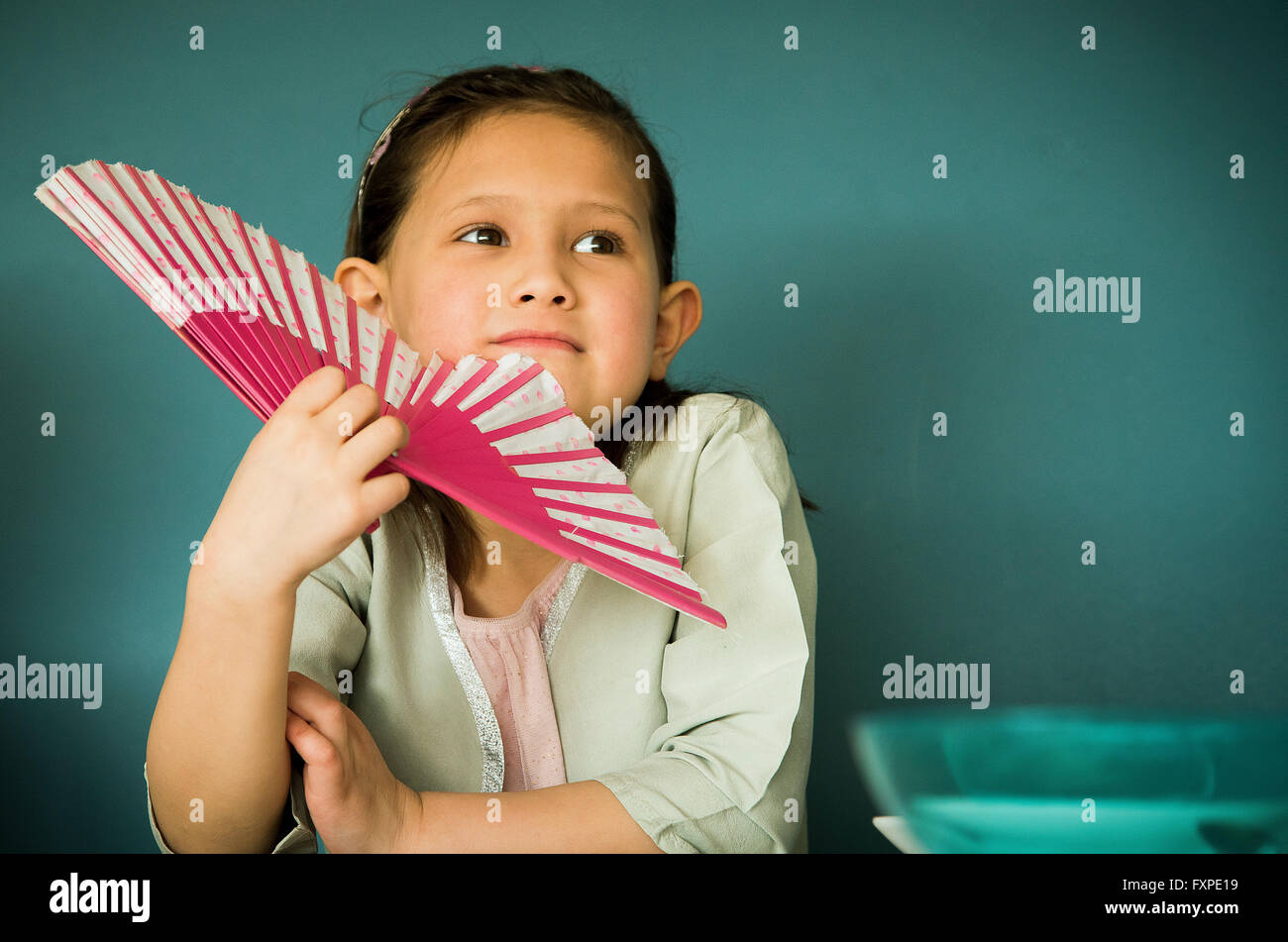 Bambina mantenendo la ventola, ritratto Foto Stock