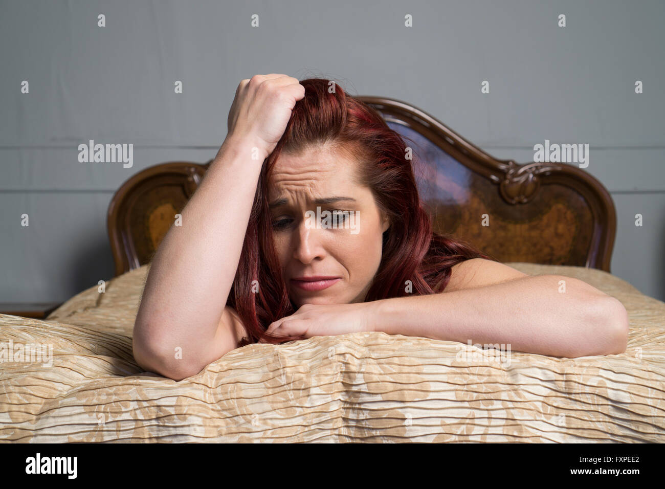 Misera donna nel letto Foto Stock
