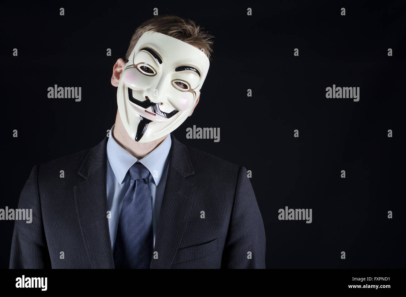 Uomo in tuta con v per vendetta maschera su sfondo nero Foto Stock