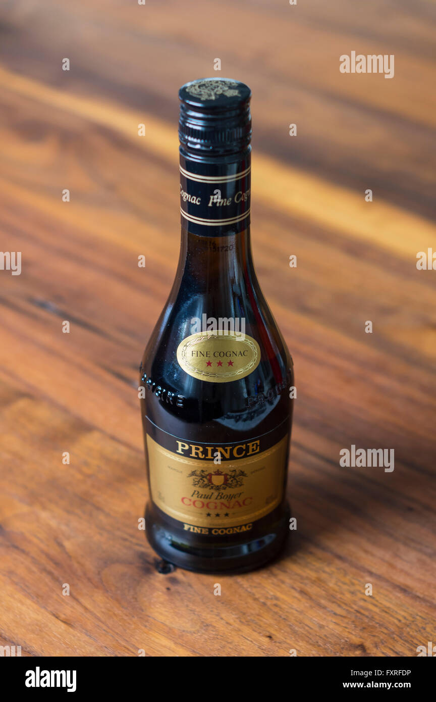 Bottiglia di Cognac su un tavolo di legno. Profondità di campo focalizzato sul logo. Foto Stock