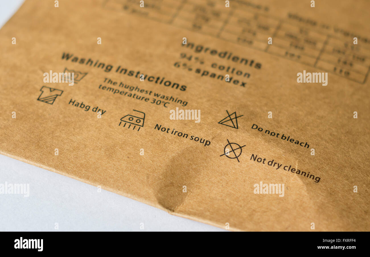 Istruzioni per il lavaggio di un indumento cinese con un sacco di errori di ortografia, compresa 'non zuppa di ferro' e 'habg dry". Foto Stock