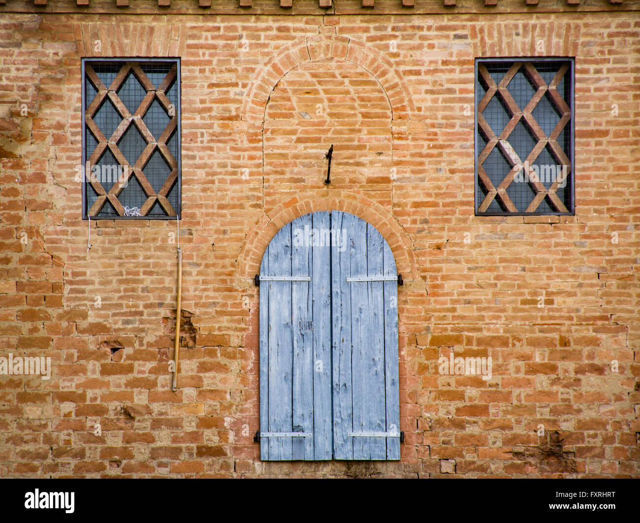 Dettaglio delle finestre di un edificio antico del borgo toscano di Buonconvento Foto Stock