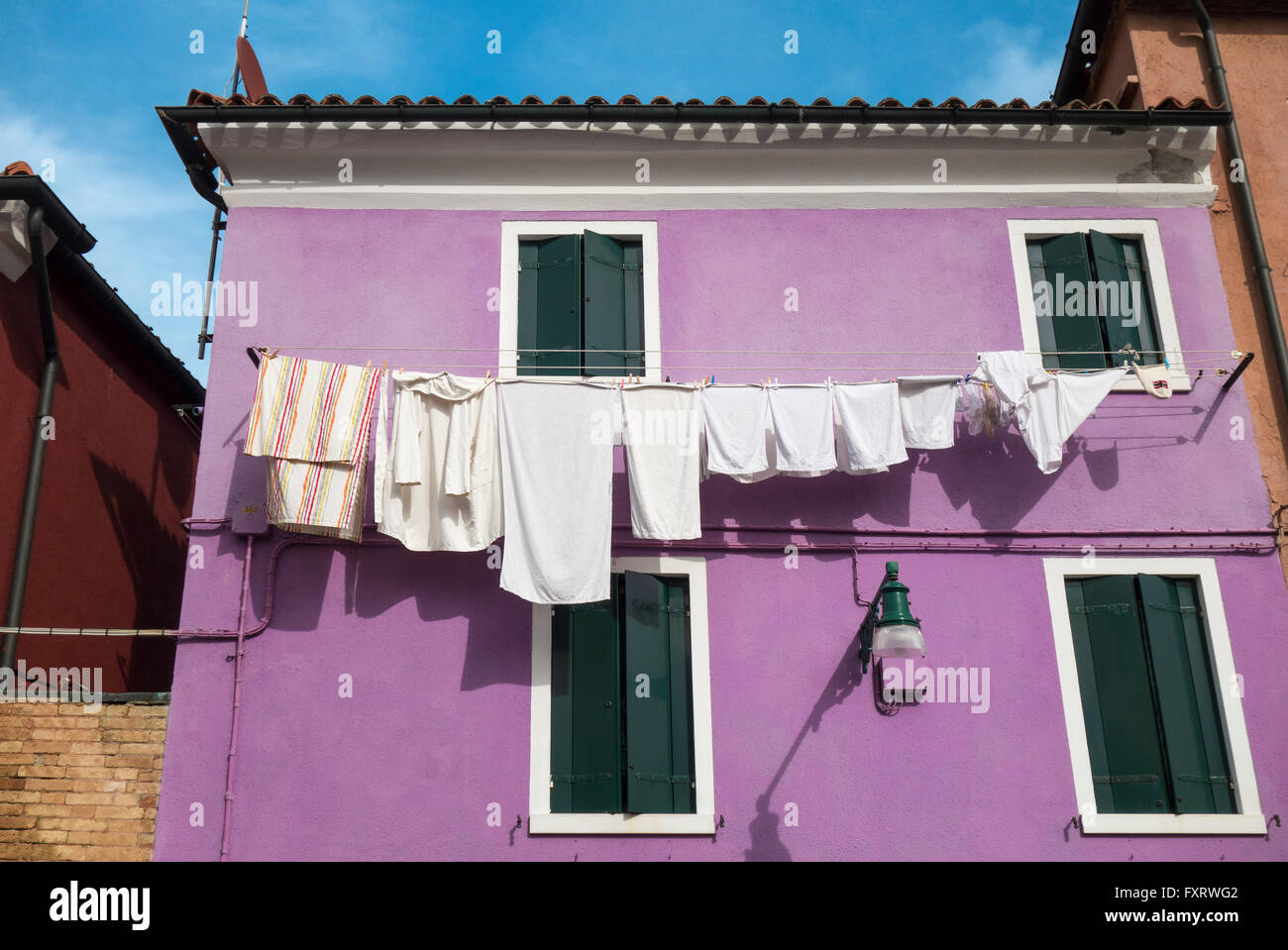 Venezia - Isola di Burano colorato colorato casa con stendibiancheria linea di abbigliamento lungo il canale. Foto Stock