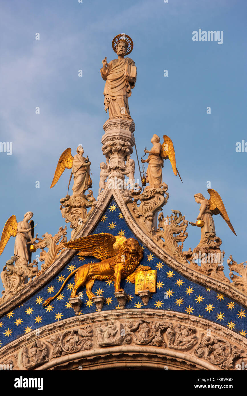 La Cattedrale di San Marco, Venezia, particolare della facciata. San Marco con gli angeli sopra il leone alato simbolo di Venezia e il san. Foto Stock