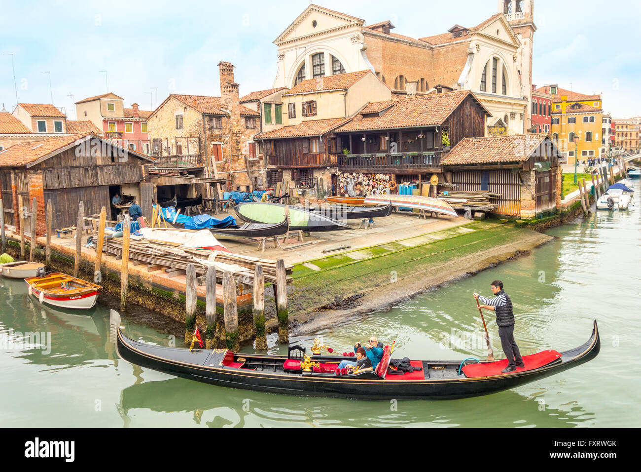 Venezia Italia. Gondola Veneziana sul Rio San Trovaso passando la gondola workshop cantiere Squero di San Trovaso nel sestiere di Dorsoduro Foto Stock