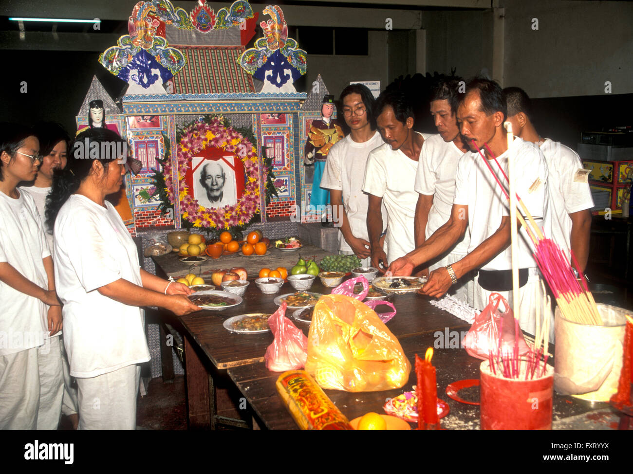 I membri della famiglia lasciando doni a un funerale cinese Foto Stock