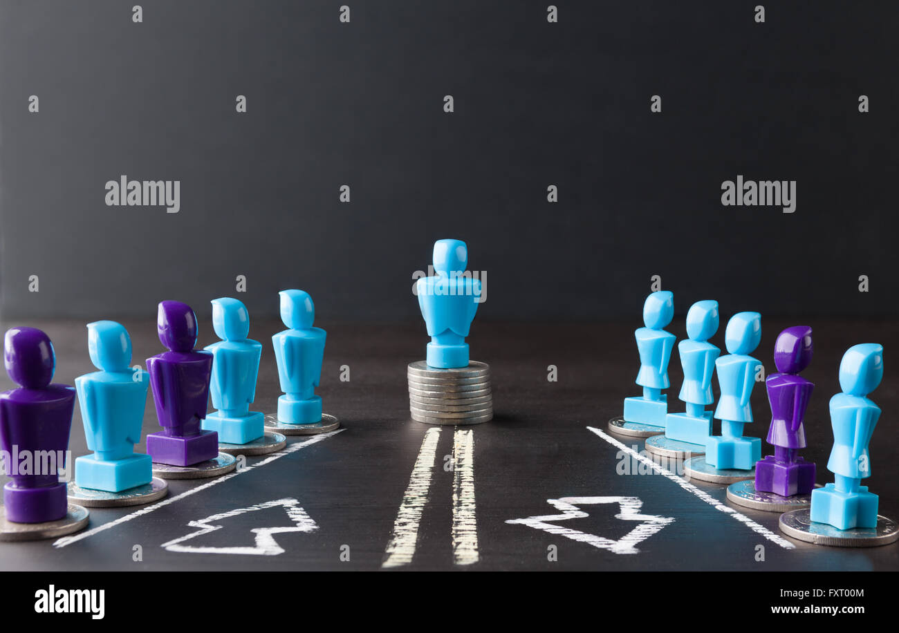 Leadership, denaro, salariale e la parità tra i sessi concetto rappresentato con la femmina e maschio di statuette in piedi sulla parte superiore delle monete. Foto Stock