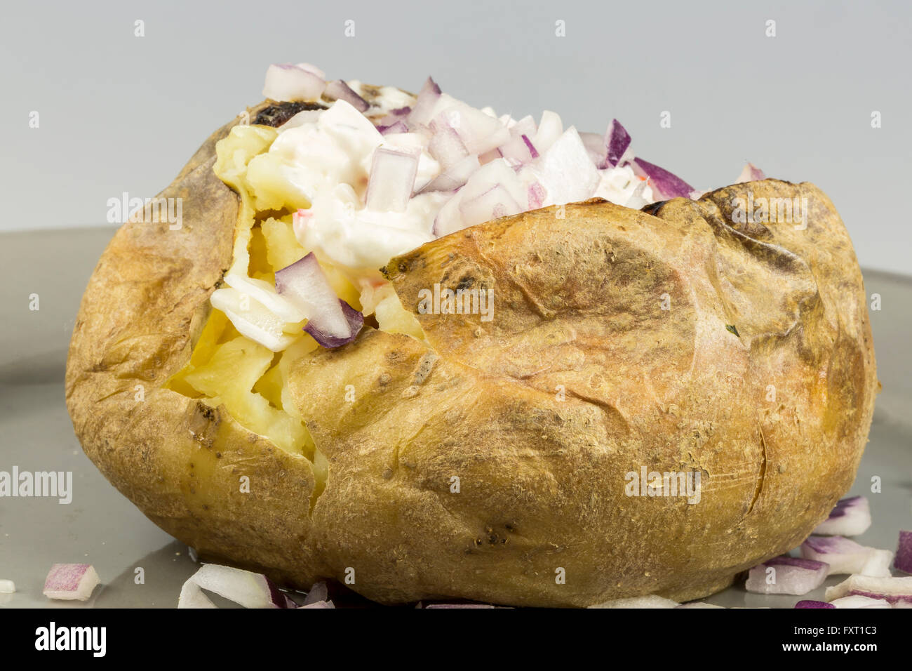 Patate al forno con cipolla rossa close up su piastra Foto Stock