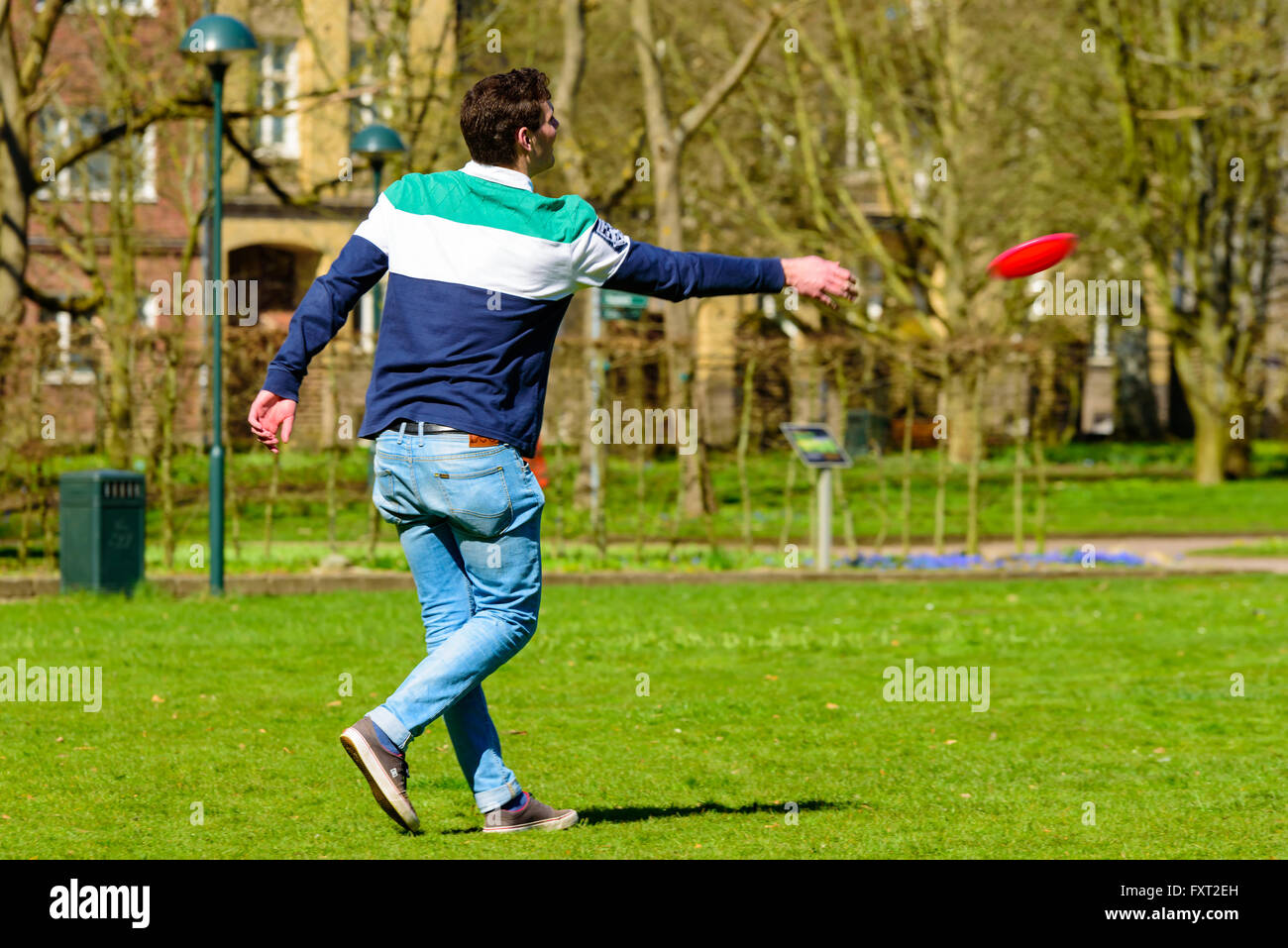 Lund, Svezia - 11 Aprile 2016: ogni giorno la vita della città. Giovane uomo adulto in un parco è di gettare una flying disc a lato. Foto Stock