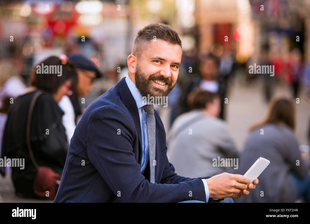 Hipster manager con il Mart telefono, Piccadilly Circus, Londra Foto Stock