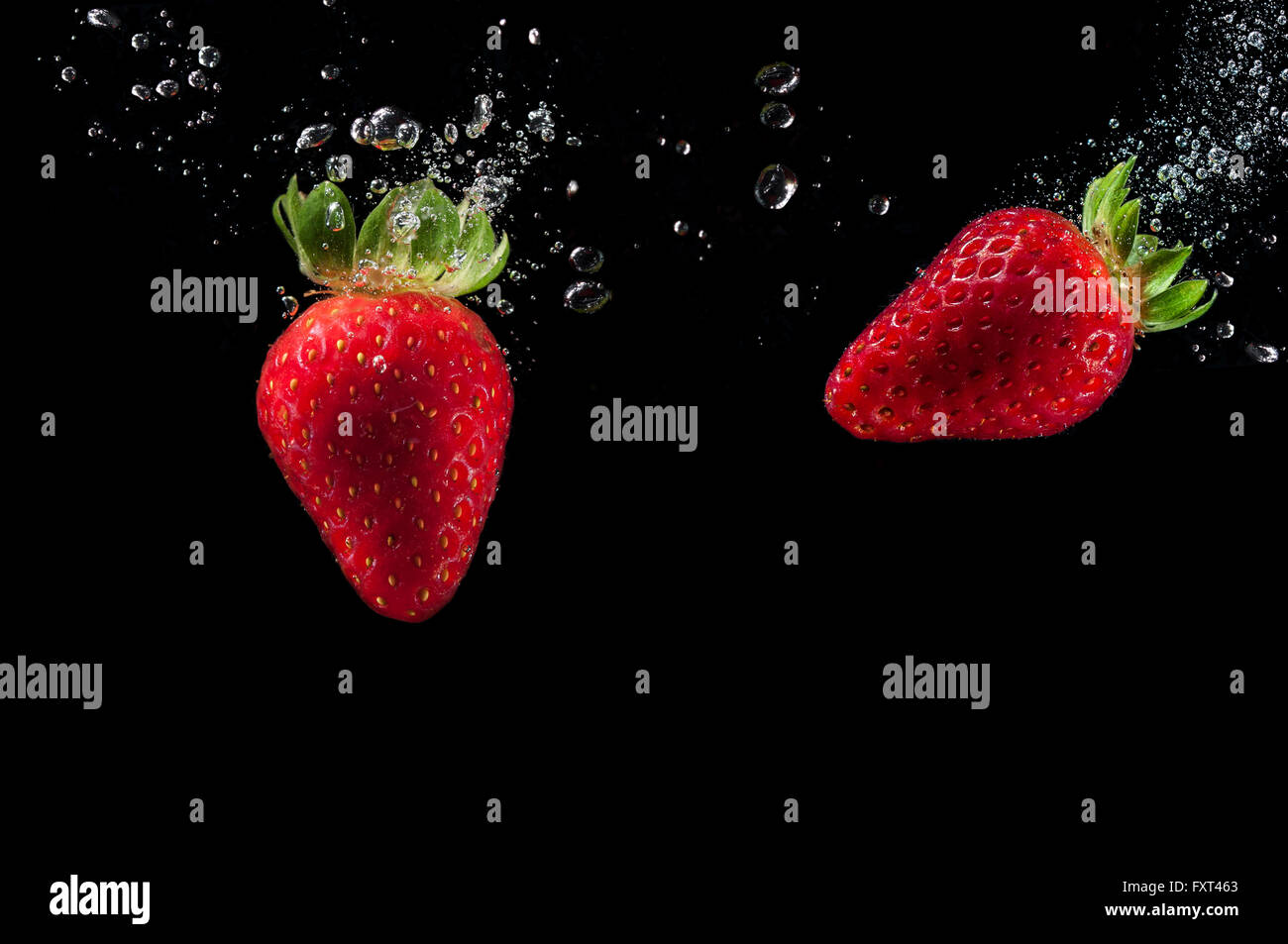 Due le fragole di schizzi in acqua Foto Stock