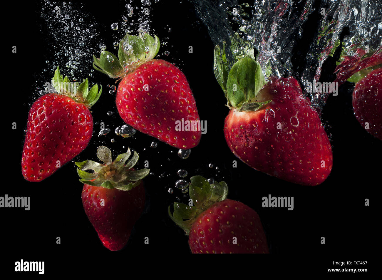 Fragole fresche caduta in acqua splash Foto Stock