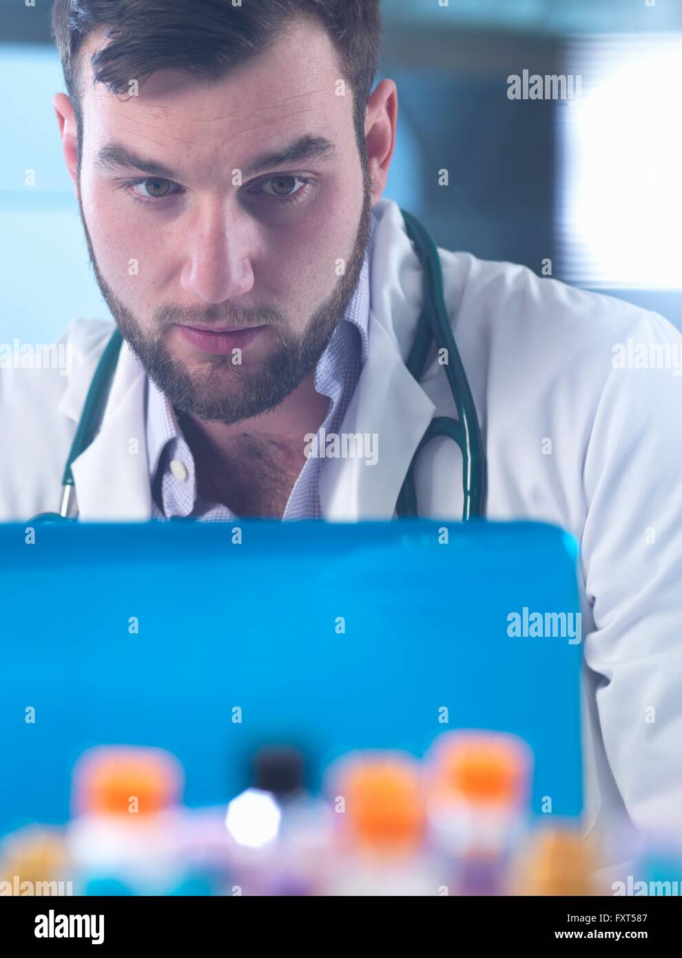 Medico di lettura medica del paziente i risultati dei test sul computer portatile, campioni in primo piano Foto Stock