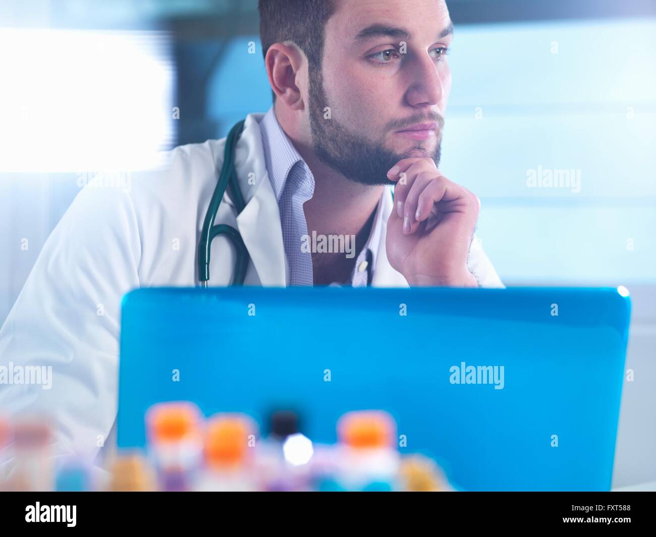Medico pensando di medici del paziente i risultati di prova, i campioni in primo piano Foto Stock