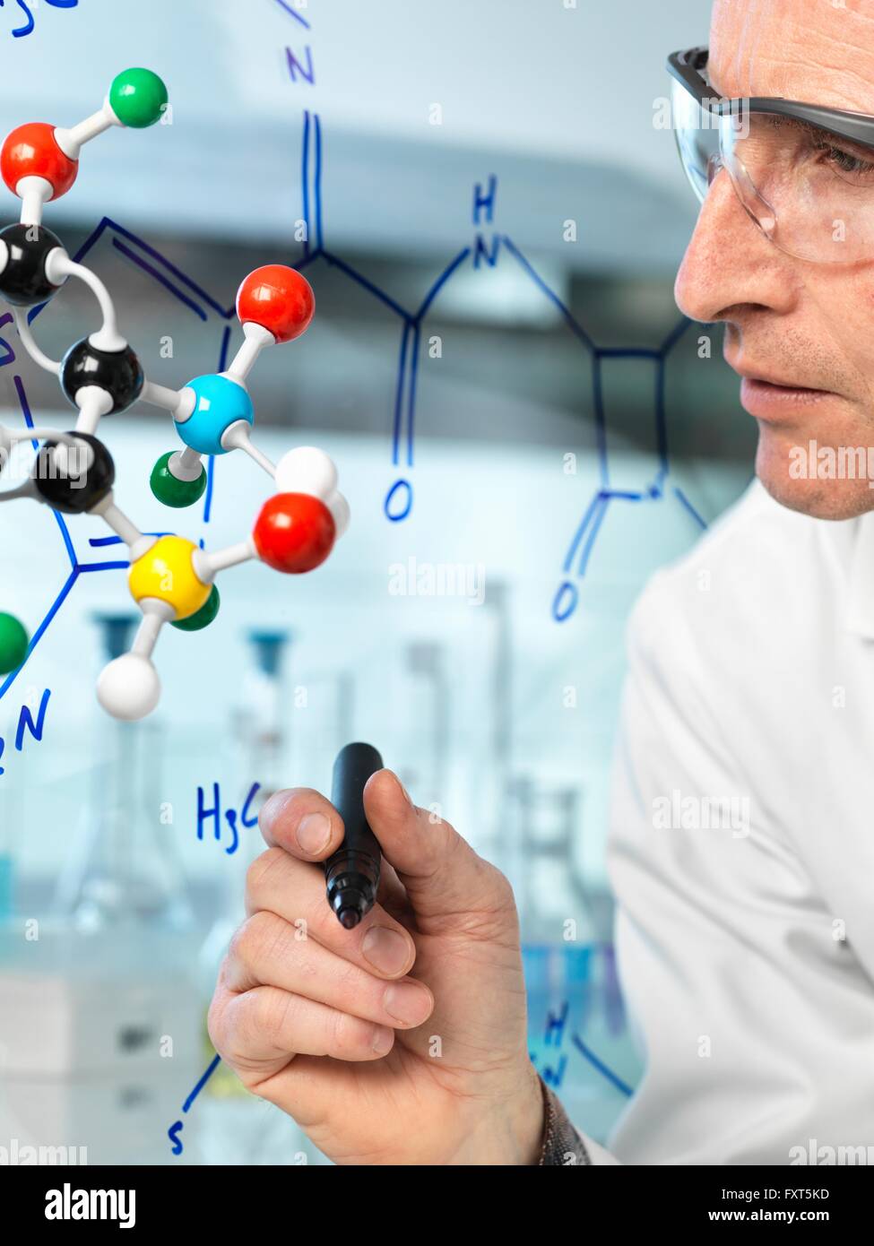 Scienziato con palla e stick modello molecolare formula di scrittura del nuovo farmaco su vetro Foto Stock