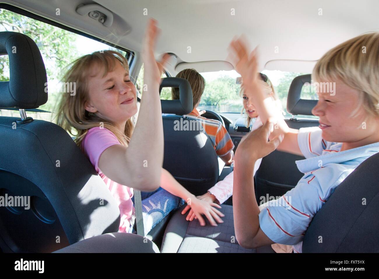 Bambini che combattono nel sedile posteriore del veicolo su strada viaggio Foto Stock