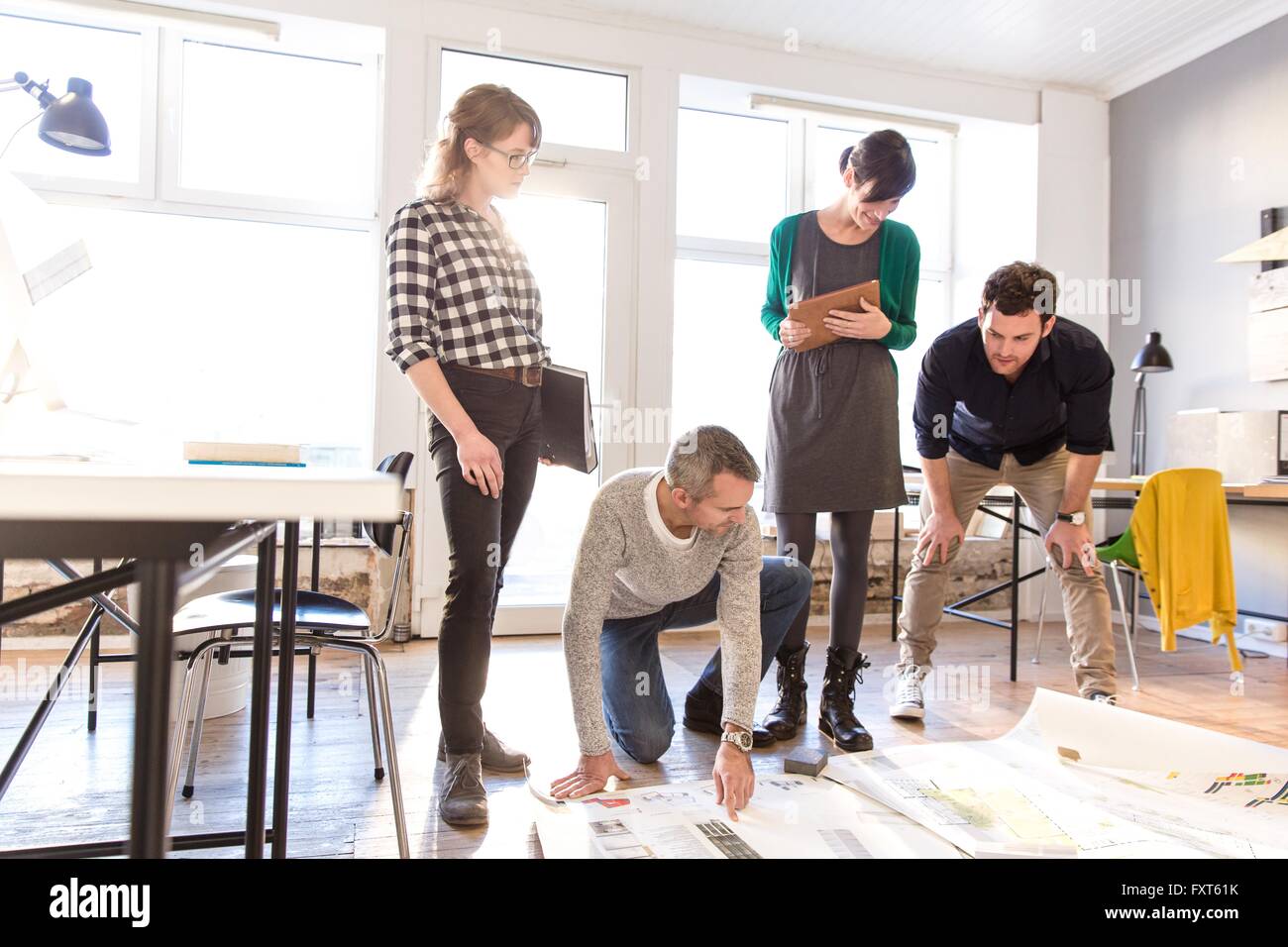 Architetti discutendo blueprint su pavimento di office Foto Stock