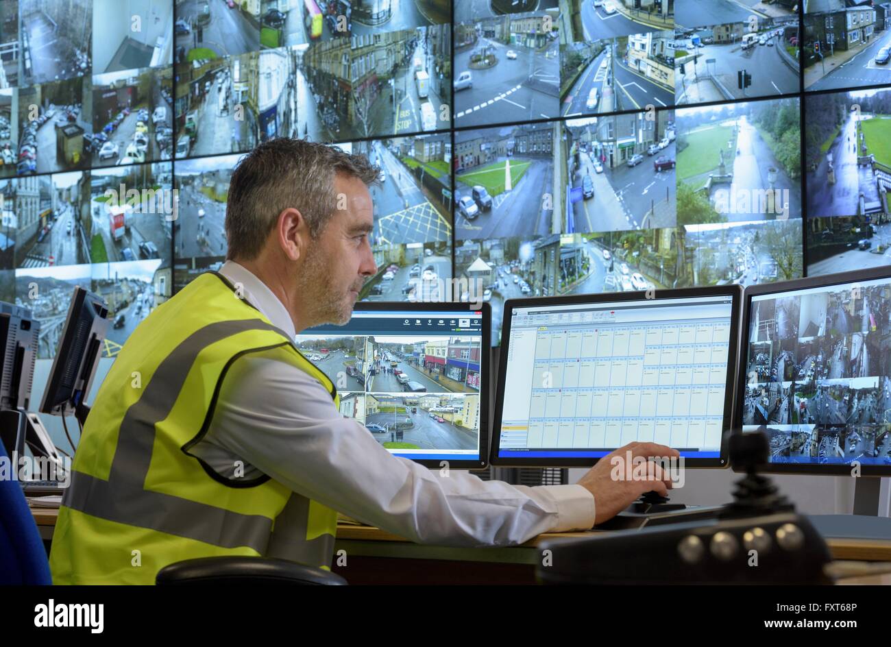 La guardia di sicurezza nella sala di controllo per la sicurezza con parete video Foto Stock