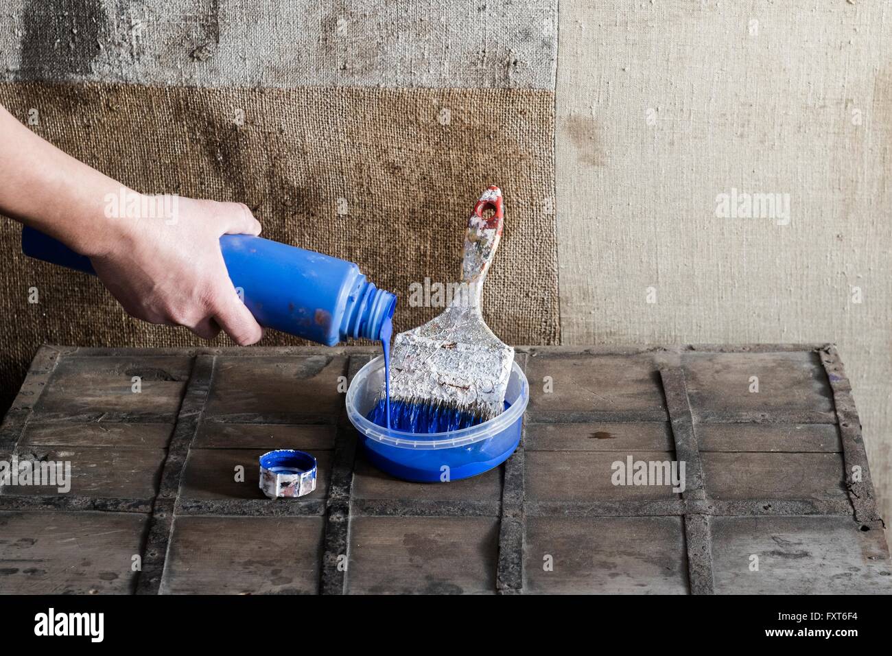 Mano di vernice di colata in un contenitore di plastica con spazzola di vernice Foto Stock